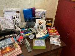 Contents of desk top and underneath: metal lamp, cable modem, twin, puzzles, office supplies, tape, waste cans, CDs, misc