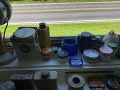 Early electric hair dryer and advertising tins and bottles on rear shelf of windowsill
