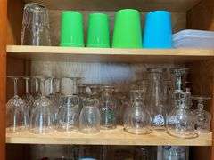Contents of two cupboards: mugs, glasses, stemware, Halloween bowls, misc