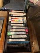 Contents of shelf: video game, VHS tapes, tape storage cases