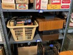 Contents of shelf: video game, VHS tapes, tape storage cases