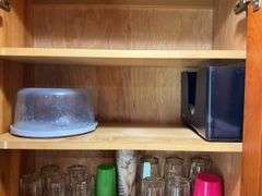 Contents of two cupboards: mugs, glasses, stemware, Halloween bowls, misc