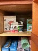 Contents of pantry cupboard: trash bags, paper goods, kitchen wrap, cookbook, misc