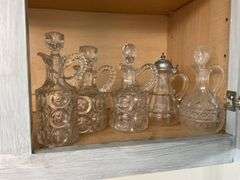 Four pressed pattern glass cruets and one syrup pitcher