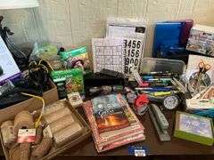 Contents of desk top and underneath: metal lamp, cable modem, twin, puzzles, office supplies, tape, waste cans, CDs, misc