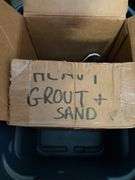 Items under workbench: plastic containers, mop wringer, grout and sand