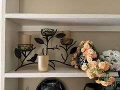 Contents of two shelves: anniversary style clock, votive holders, figurines, decor items