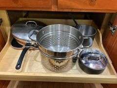 Contents of cupboard: cookware, steamer basket, lid rack