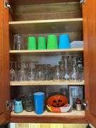 Contents of two cupboards: mugs, glasses, stemware, Halloween bowls, misc