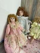 Five porcelain collector dolls, doll stands, cushion