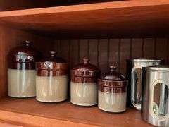 Contents of shelf: 2-tone stoneware canisters, metal canister set