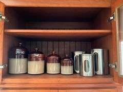 Contents of shelf: 2-tone stoneware canisters, metal canister set
