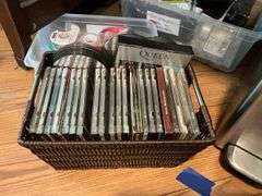 Contents of desk top and underneath: metal lamp, cable modem, twin, puzzles, office supplies, tape, waste cans, CDs, misc