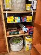 Contents of pantry cupboard: trash bags, paper goods, kitchen wrap, cookbook, misc
