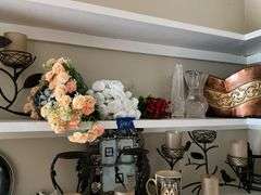 Contents of two shelves: anniversary style clock, votive holders, figurines, decor items
