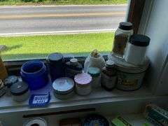 Early electric hair dryer and advertising tins and bottles on rear shelf of windowsill