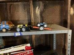 Contents of shelf: Tonka toy trucks and earthmover, Tonka dunebuggy, Nylint trailer