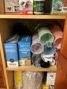 Contents of pantry cupboard: trash bags, paper goods, kitchen wrap, cookbook, misc