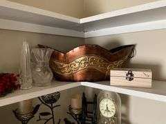 Contents of two shelves: anniversary style clock, votive holders, figurines, decor items