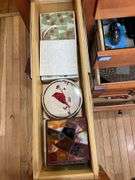 Contents of four drawers and one cupboard: coasters, baking pans, gadgets, hot pads, rolling pin, misc