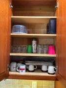 Contents of two cupboards: mugs, glasses, stemware, Halloween bowls, misc