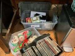 Contents of desk top and underneath: metal lamp, cable modem, twin, puzzles, office supplies, tape, waste cans, CDs, misc