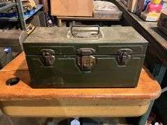 Contents of shelf: vintage cosmetic case, movie reels, metal toolbox, roll of plastic