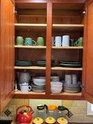 Contents of cupboard: Dansk stoneware dinnerware, green glazed pinecone motif dinnerware