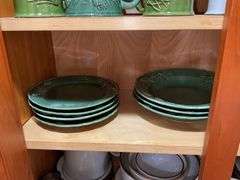 Contents of cupboard: Dansk stoneware dinnerware, green glazed pinecone motif dinnerware