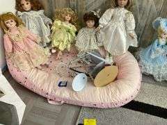 Five porcelain collector dolls, doll stands, cushion