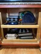 Contents of cupboard: Corningware casseroles, various baking pans, trays