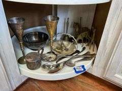 Contents of shelf: metalware - brass figurines and bells, aluminum basket, plated items, flatware