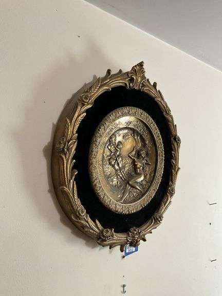 Cast metal plaque on black mount in gilt frame 19.5x21