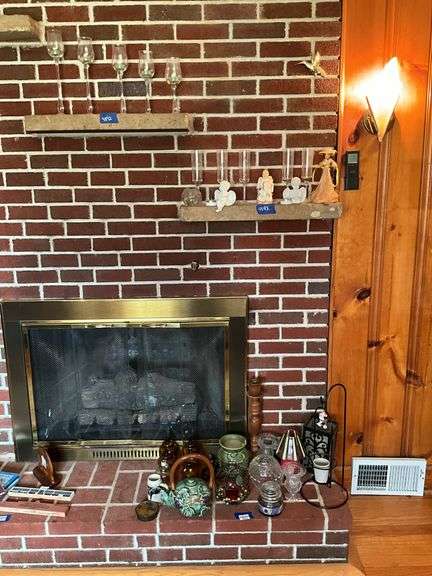 Contents on right corner of hearth, and two shelves above: decor items, candles, figurines, misc
