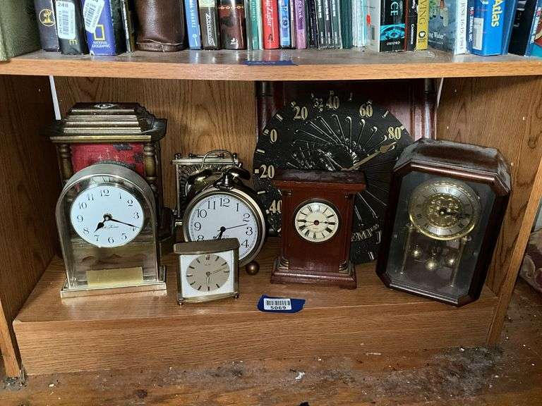 Contents of shelf: desk clocks, anniversary clock, alarm clocks, wall thermometer