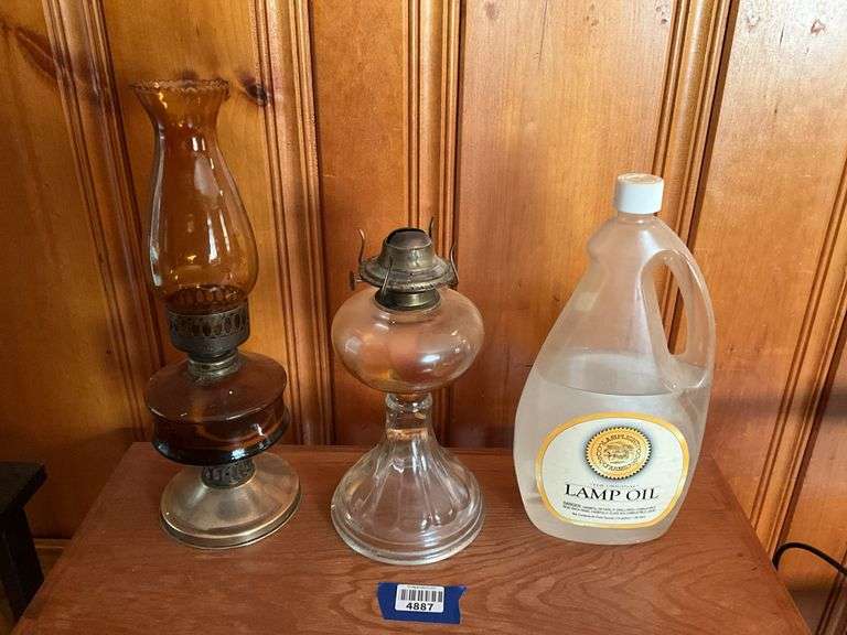 Two glass oil lamps and bottle of lamp oil