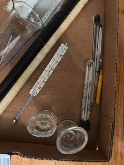 Glass eye wash cups, graduated beaker, thermometers