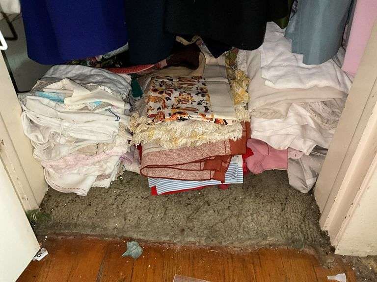 *In living room* Contents of closet: ladies jackets sz: lg/16, tablecloths and linens lot