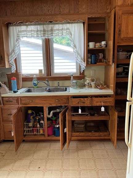 Contents of four cupboards and two drawers: flatware, cookware, Pyrex measuring cups, baking dishes, glassware, under sink contents