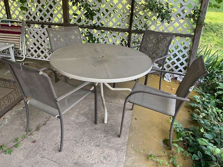 Round glass top patio table and four arm chairs