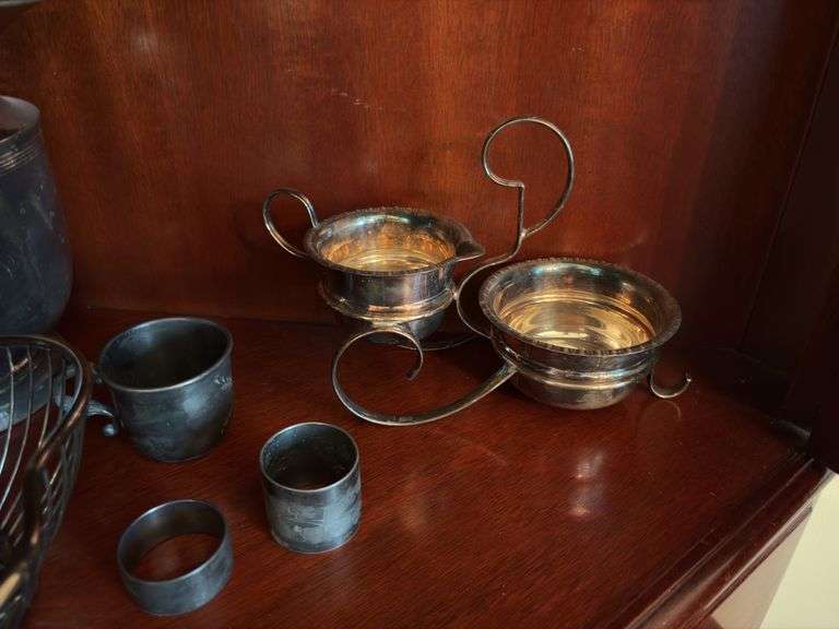 Contents of two shelves: silverplated tea and coffee pots, misc serving pcs