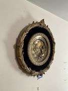 Cast metal plaque on black mount in gilt frame 19.5x21