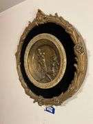 Cast metal plaque on black mount in gilt frame 19.5x21