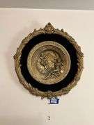 Cast metal plaque on black mount in gilt frame 19.5x21