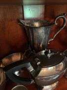 Contents of two shelves: silverplated tea and coffee pots, misc serving pcs