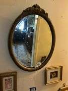 Oval beveled mirror in gilt frame w/ carved crest 18x24