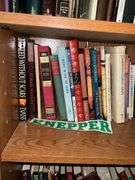 Book contents of four shelves: Bibles, golf, reference, misc