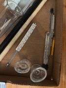 Glass eye wash cups, graduated beaker, thermometers