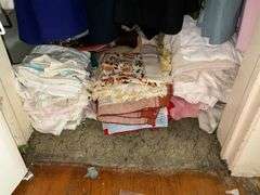 *In living room* Contents of closet: ladies jackets sz: lg/16, tablecloths and linens lot