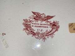 Contents of shelf: red Staffordshire transfer printed china including White Mountain NH scene and Columbus